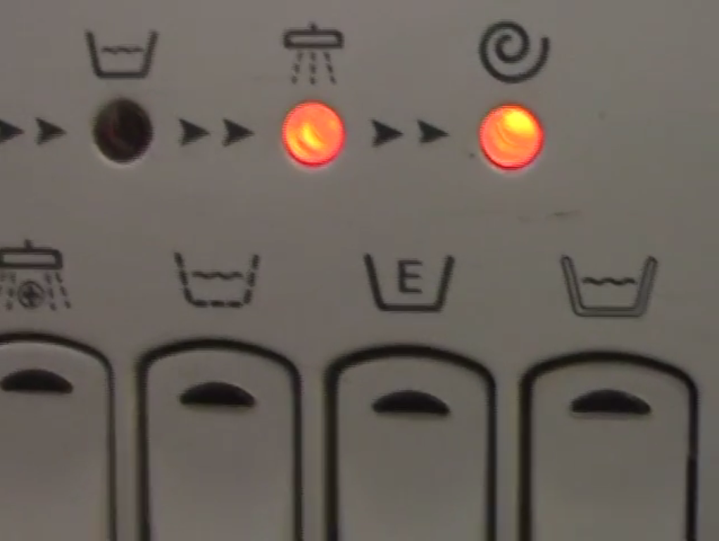 The image pictures the buttons and lights on a washing machine, with their various functions like hand-wash and spin-cycle.